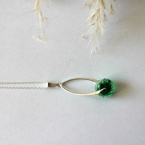 Collier torsadé avec une perle de verre verte.